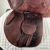 Image of used Intrepid Pro-Trainer Gold Deluxe jump saddle's near side billets with cover.